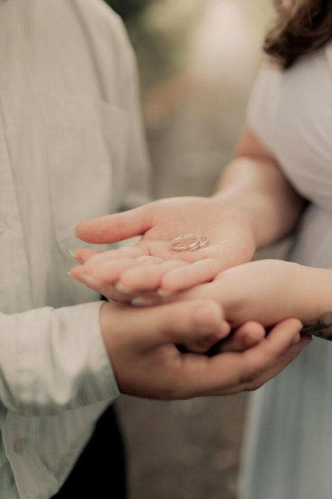 Close-up of couple exchanging rings, symbolizing love and commitment.